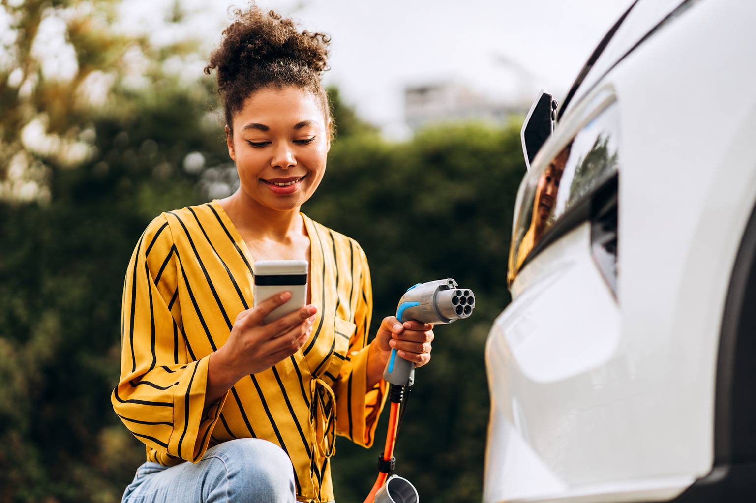 Woman charging an electric vehicle